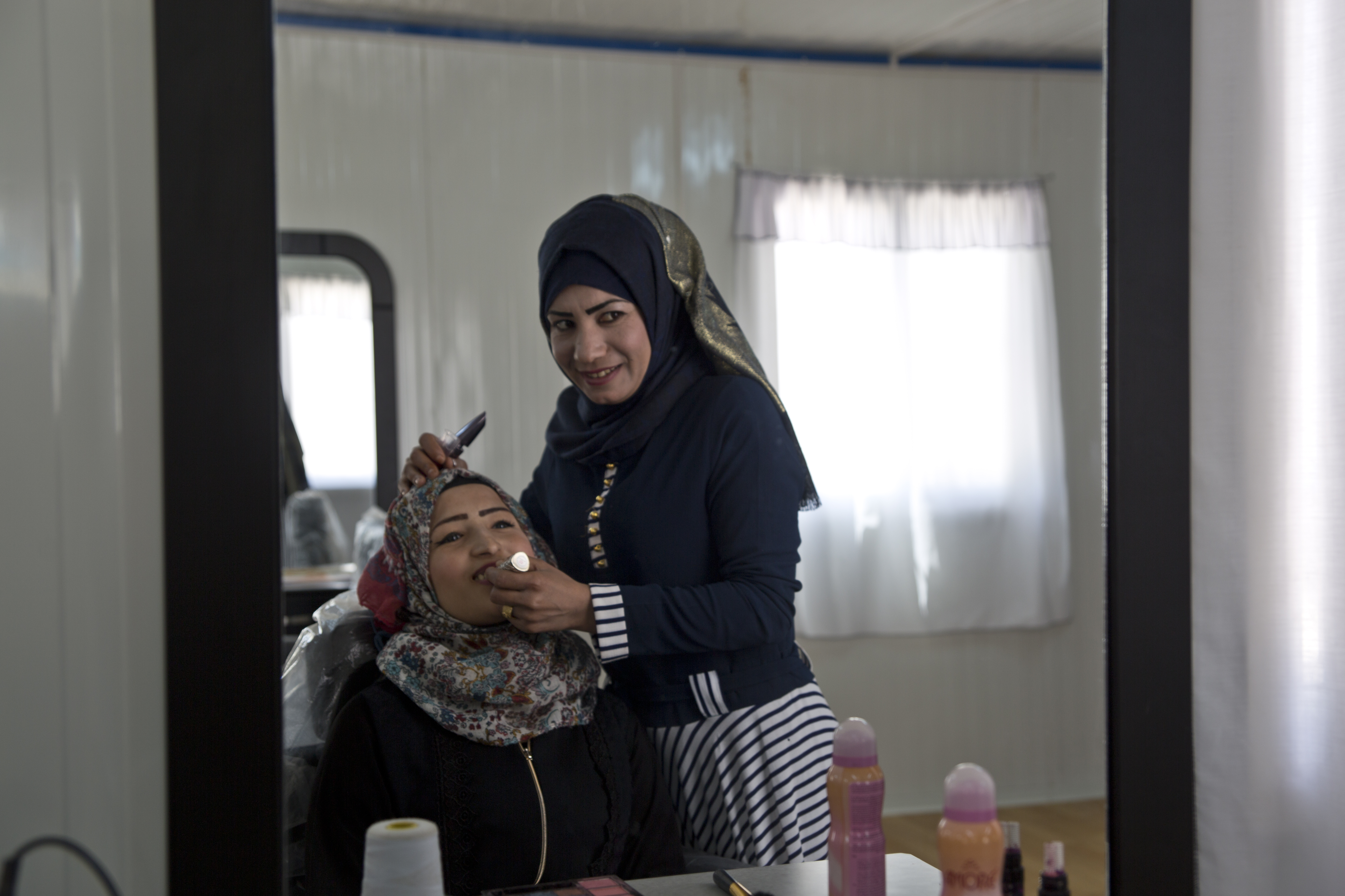 Intesar Hassan supports her family by working as a beautician within the cash-for-work program within the Azraq UN Women Oasis for 'Women and Girls.' Photo source: UN Women/Lauren Rooney  