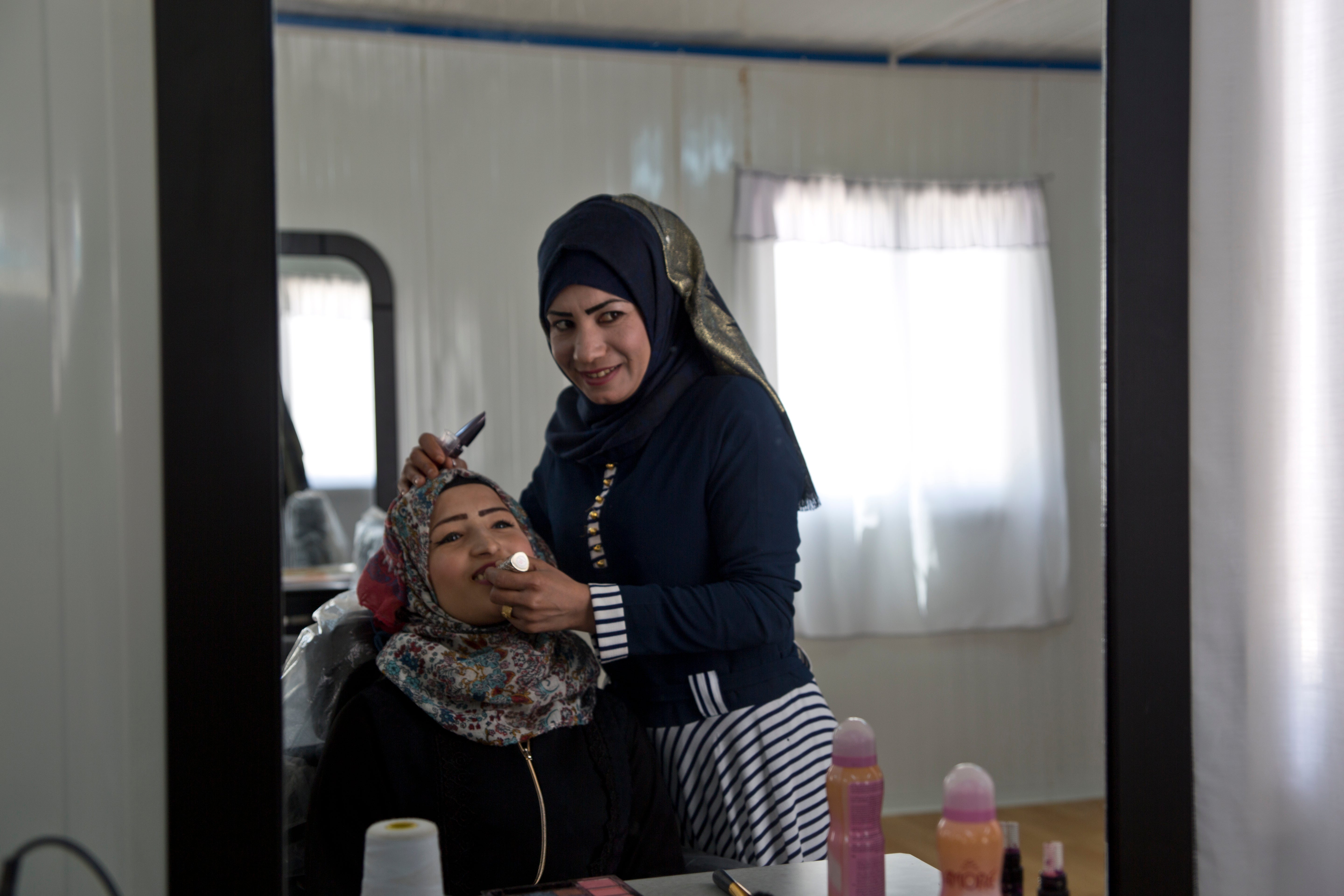 Intesar Hassan supports her family by working as a beautician within the cash-for-work program within the Azraq UN Women Oasis for 'Women and Girls.' Photo source: UN Women/Lauren Rooney  