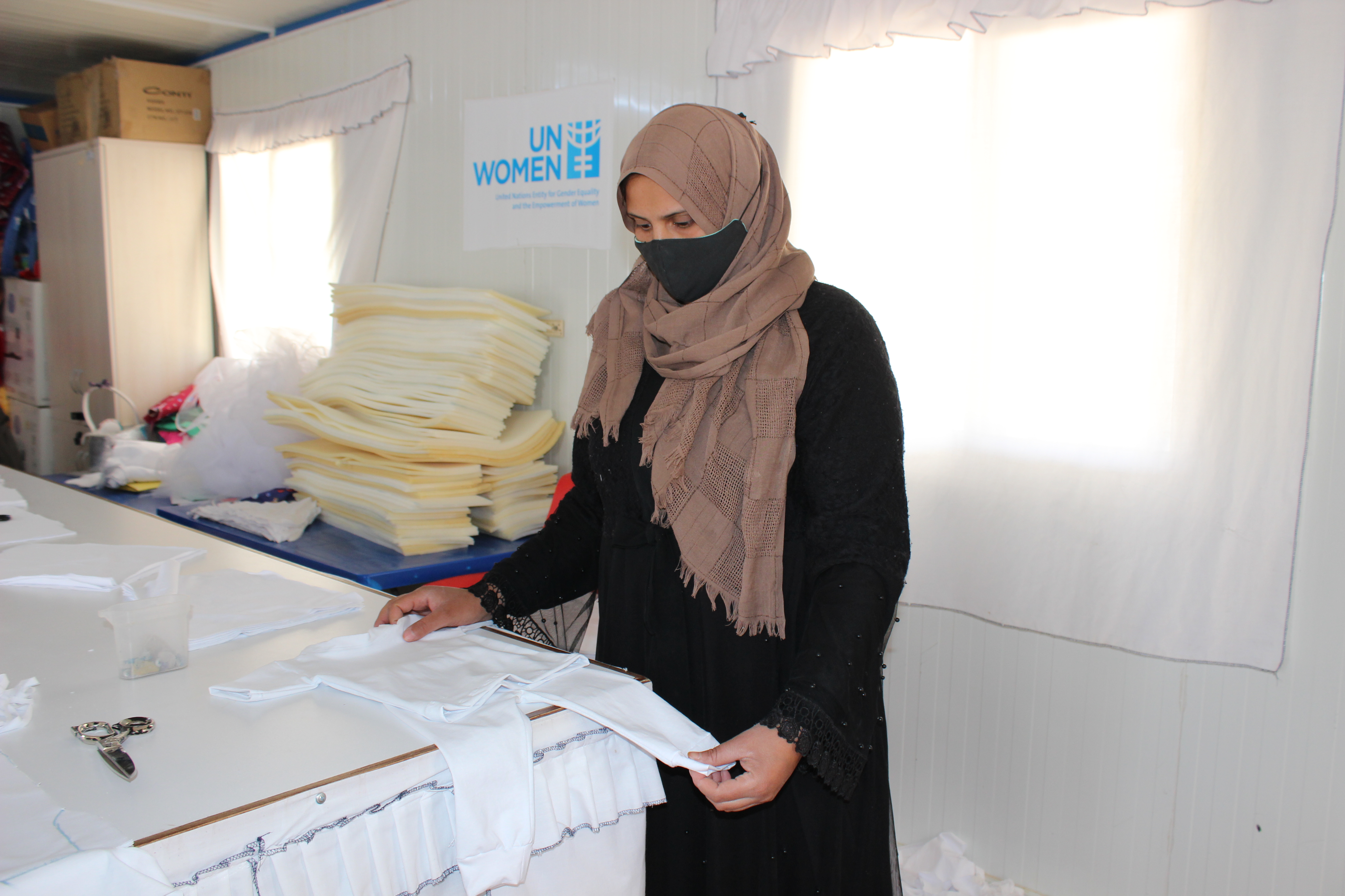 Nofa Ali Shadeh, 33, works on a baby suits at the UN Women Oasis center in the Azraq refugee camp. Photo: UN Women/Yeji Lee