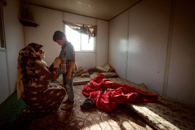 A Syrian mother prepares her child for school before going to work at the ‘Women and Girls Oasis’ programme. (UN Women/Christopher Herwig)