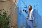 Samaher in front of the Zaatari Oasis centre gate where she works. 