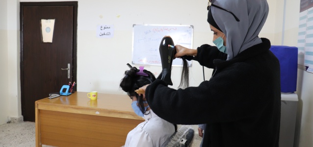 Wijdan Al-Abbadi demonstrates hairstyling techniques during the beautician course at the Oasis Centre in Iraq Al-Amir. Photo: UN Women/Ye Ji Lee