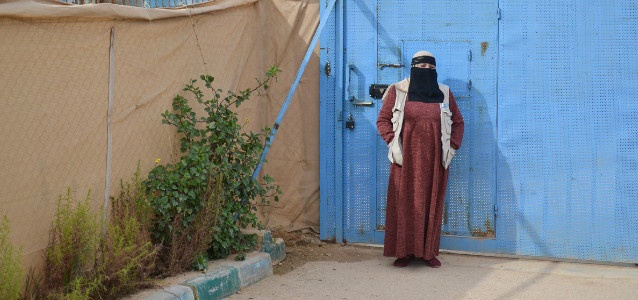 Fatima in front of the Zaatari Oasis centre gate where she works. 